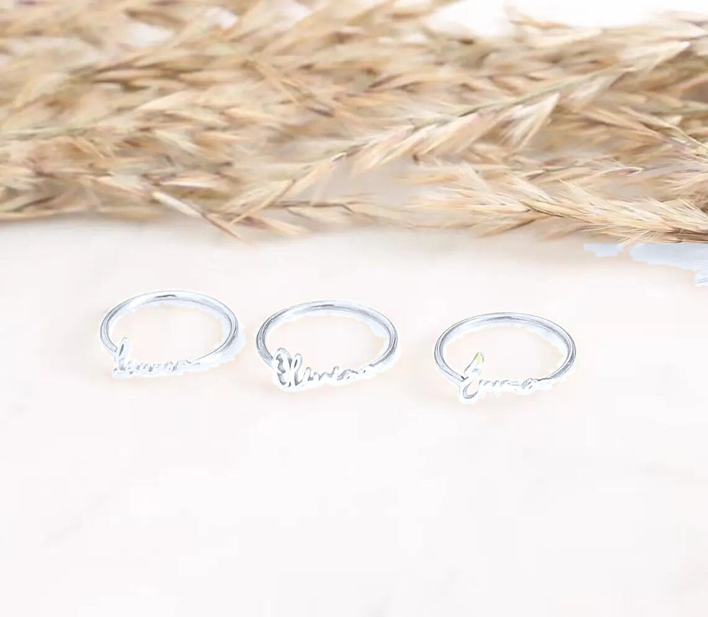 Three silver name rings (colour adjusted in the photo)