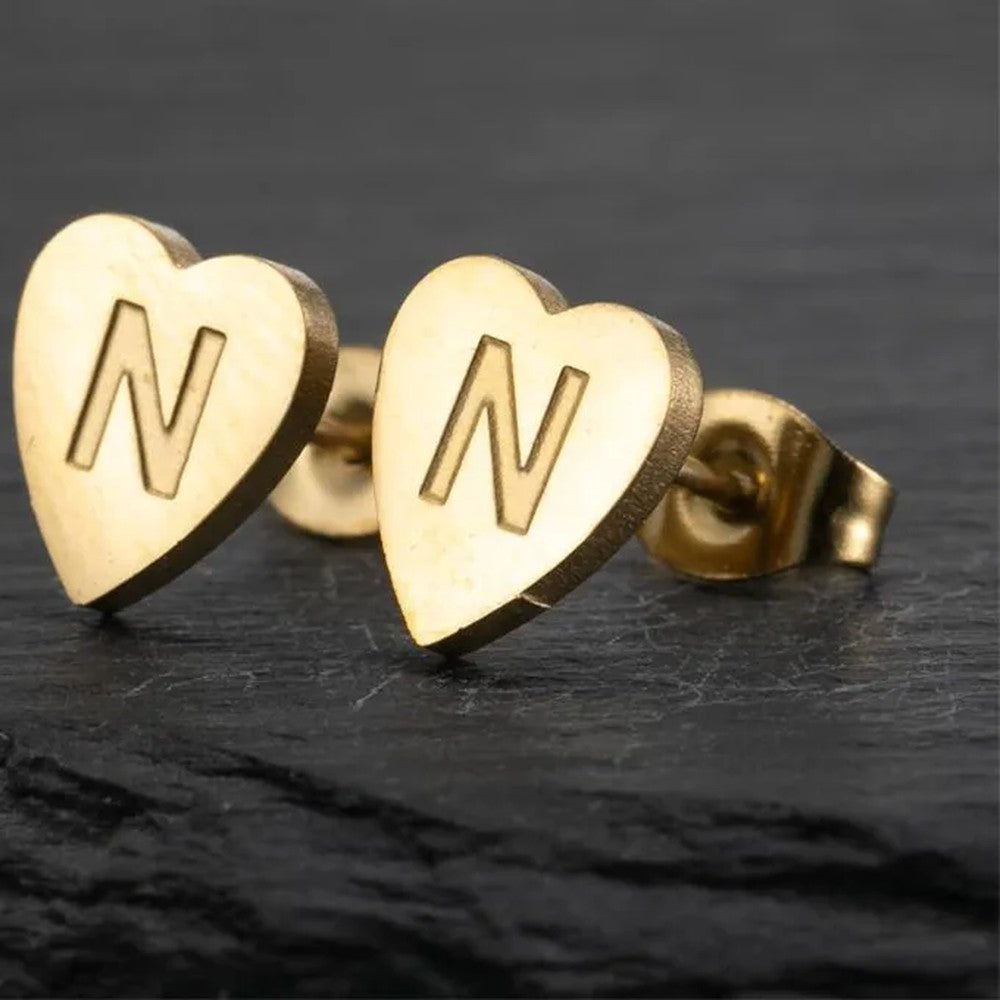 Detalle de los pendientes dorados de corazón con la inicial N
