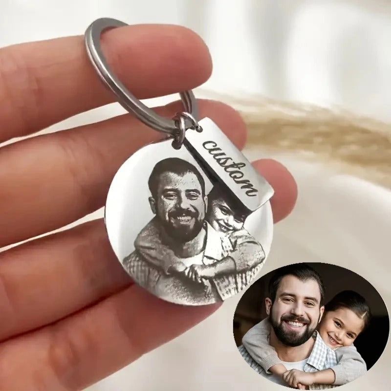 Engraved photo keyring in the hand, next to the original photo