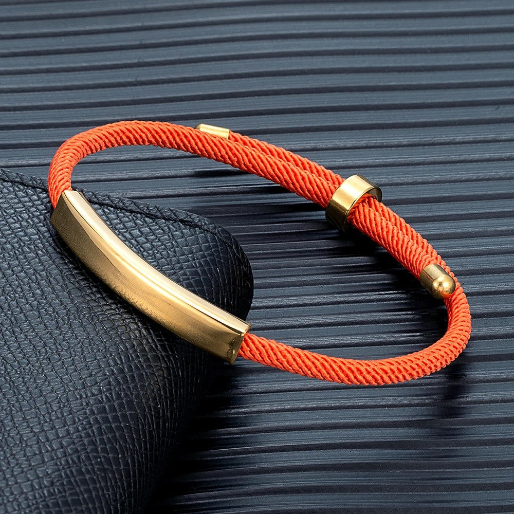 Pulsera de cordón naranja con la placa dorada