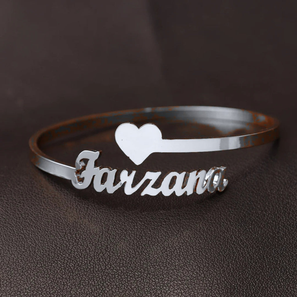 Pulseira rígida prateada com um nome e coração (cor ajustada na fotografia)
