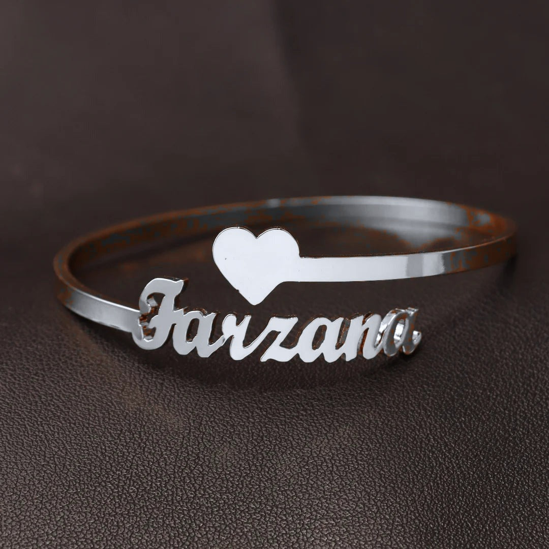 Silver bangle with one name and a heart (colour adjusted in the photo)