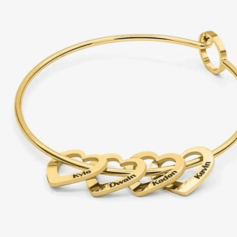 Pulseira rígida dourada com quatro corações gravados com nomes