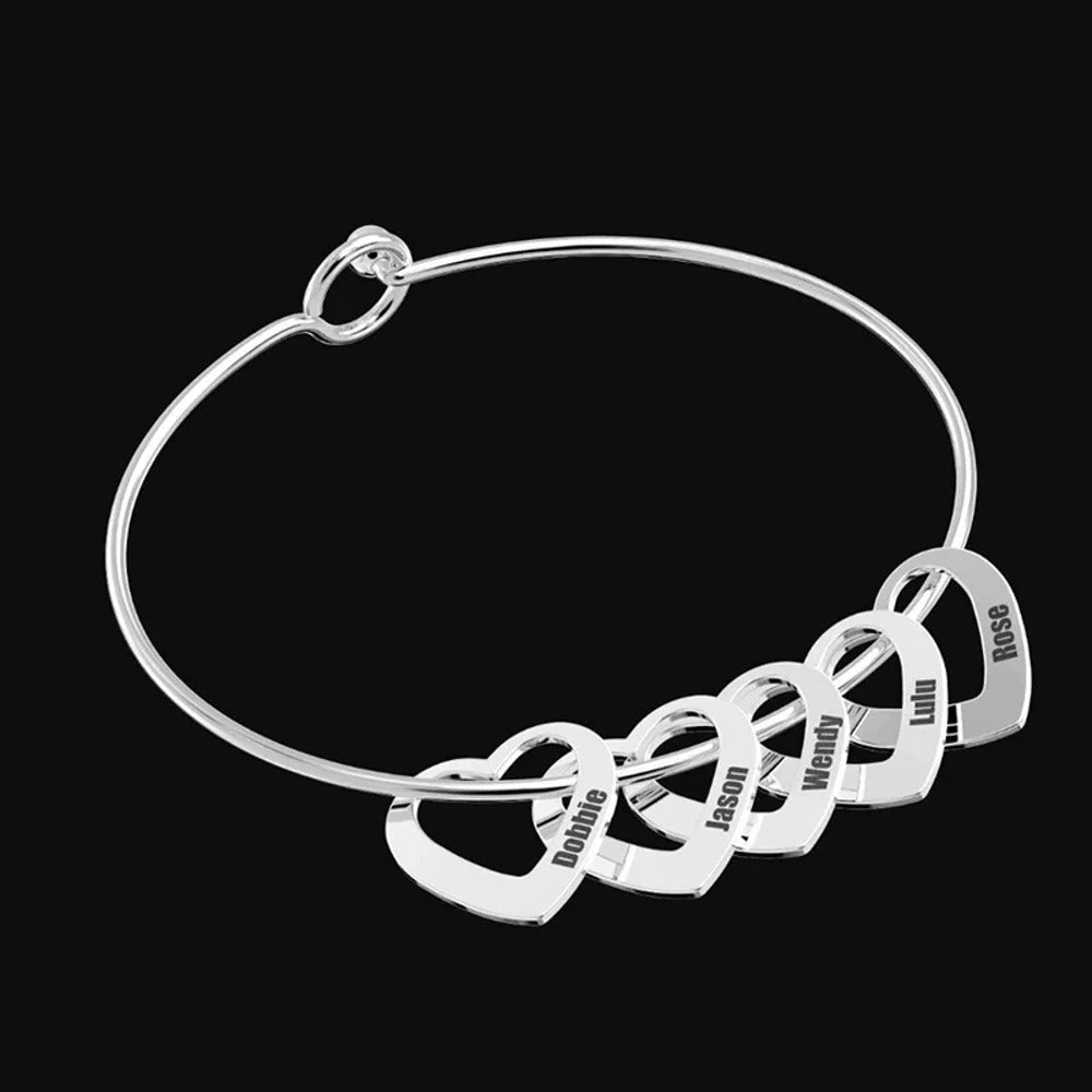 Pulseira rígida prateada com seis corações gravados com nomes