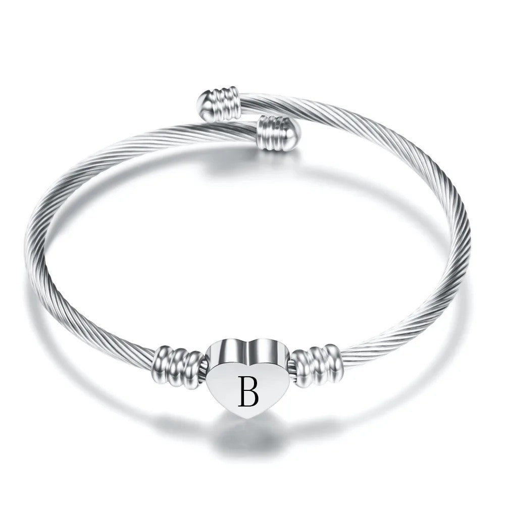 Pulsera rígida plateada con un corazón y la inicial B